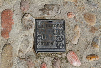 Iron cast hatch of Natural gas on the paving road in Besalu (Catalonia, Spain)