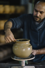 man that works in the factory of pottery