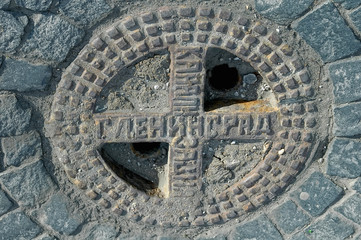 Saint-Petersburg, Russia - May 15, 2006: Old manhole cover on asphalt