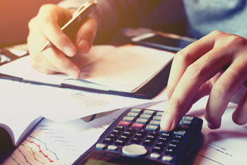 Close up hand man doing finance and calculate about cost with thinking problem.