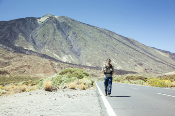 traveler man hitchhiking in Tenerife with the Teide on the background