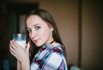 A girl holds a glass of milk