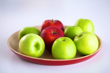 Still life arrangement of apples on a wooden platter