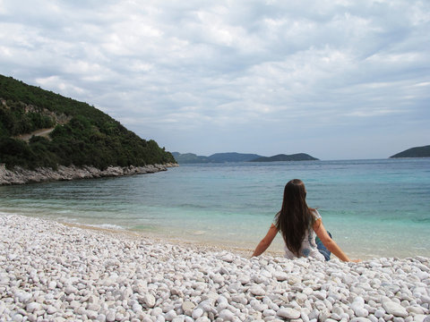 woman isolated in a pebbles beach in Croatia