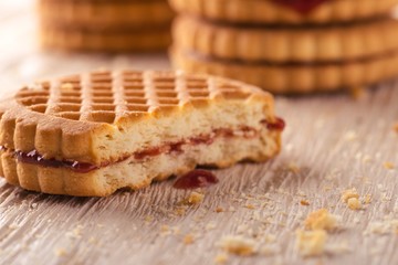 Several biscuits with red homemade marmalade on white board