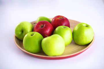 Still life arrangement of apples on a wooden platter