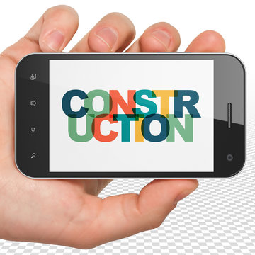Building construction concept: Hand Holding Smartphone with Construction on  display