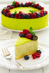 Home pistachio cheesecake with raspberries and blueberries.