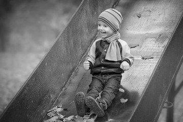 Little boy and leaves of autumn