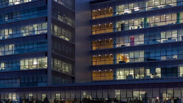 Office building, with illuminated interior at dusk, in the city of Barcelona.Motion Camera Panning Right.
