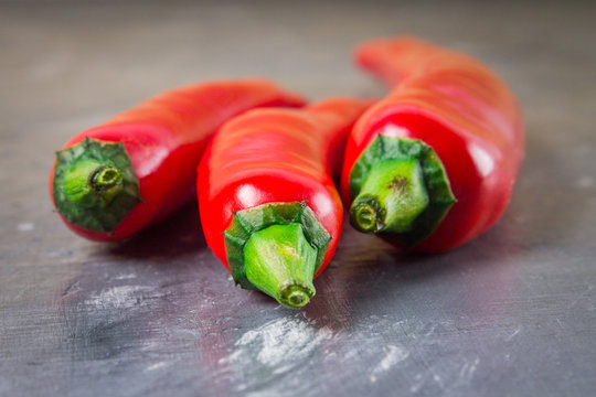 Fresh red cilli peppers isolated on gray background.