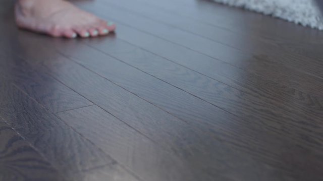 mopping hardwood floor with bare feet -stylish house wife
