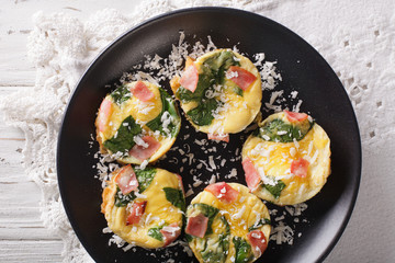frittata with spinach, ham and cheese on a plate close-up on the table. horizontal top view