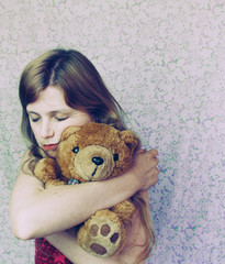 Chica joven con nostalgia de su infancia abraza su oso de peluche 