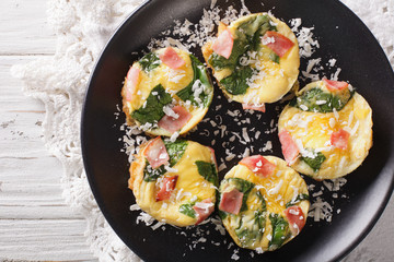 Omelet with spinach, ham and cheese on a plate close-up on the table. horizontal top view