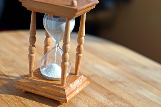 Sand clock on wooden table with free space