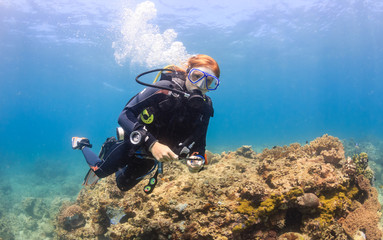 Female SCUBA diver on a shallow coral reef