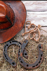 Horseshoes with leather hat , hay, straw hearts on wooden 