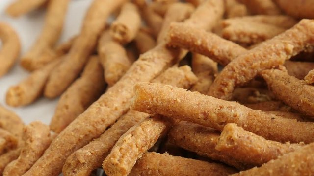 Tasty integral breadsticks fried in oil close-up slow pan 4K 2160p 30fps UltraHD footage - Served grissini snack made of dough with chilli 3840X2160 UHD panning video