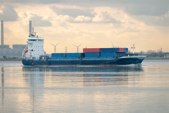 Feeder ship. Cargo container vessel on industrial river.