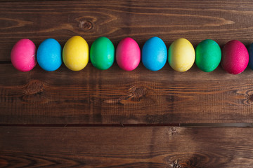 Colorful Easter eggs  on rustic wooden  background . Easter greeting card