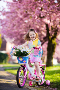 Little girl riding a bike. Child on bicycle.