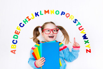 Child learning letters of alphabet and reading