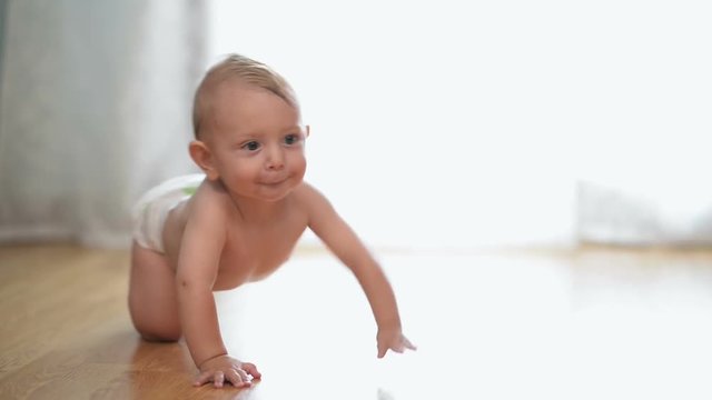 Happy baby go on all fours on the floor at home