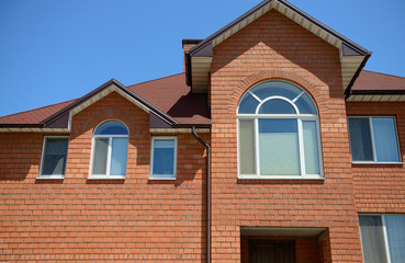 Close-up facade of red bricks, cottage house in sunlight.