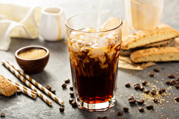 Iced coffee being poured in a glass