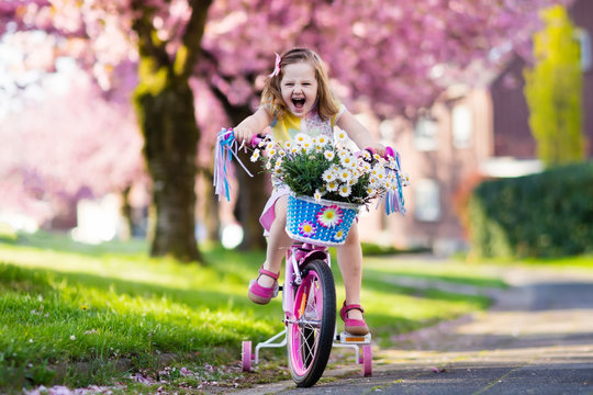 Little girl riding a bike. Child on bicycle.