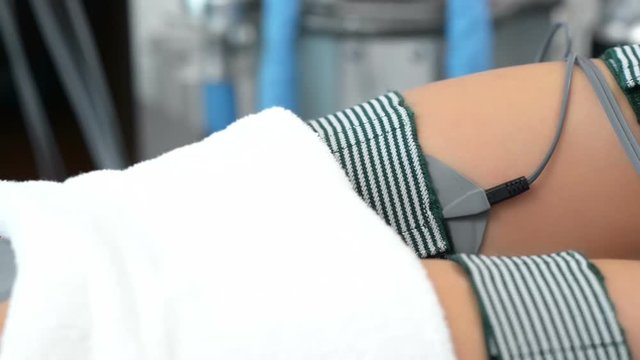 Beautiful woman getting electrostimulation therapy at beauty salon