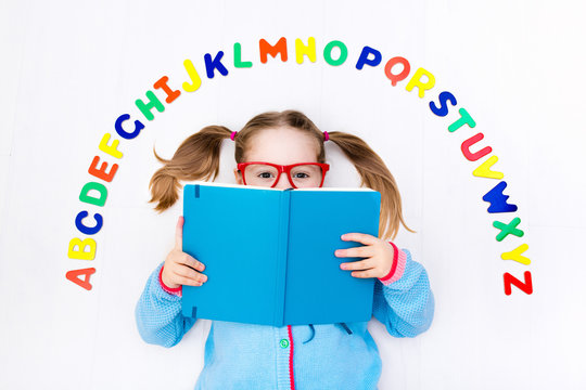 Child learning letters of alphabet and reading
