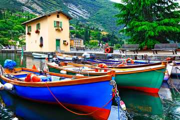 Pictorial scenery with boats in beautiful lake Lago di Garda. Torbole village. Italy