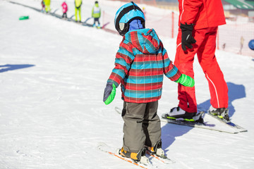 Young skier and ski instructor in beginners area