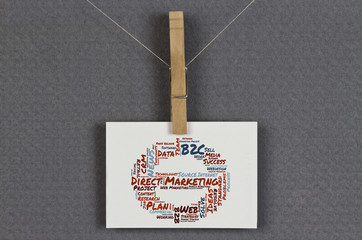 Direkt Marketing word cloud shaped as a stop sign on a business card pinned up on a board