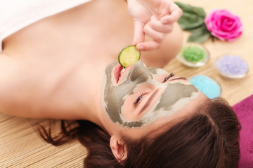 Obraz na płótnie Canvas people, beauty, spa, cosmetology and skincare concept - close up of beautiful young woman lying with closed eyes and cosmetologist applying facial mask by brush in spa