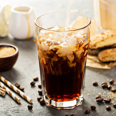 Iced coffee being poured in a glass