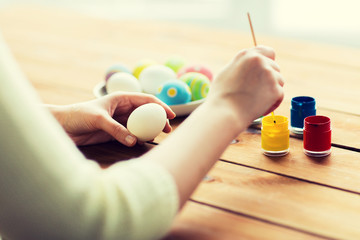 close up of woman coloring easter eggs