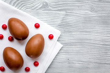 Easter chocolate eggs top view on wooden background mock up