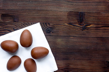 Easter chocolate eggs top view on wooden background mock up
