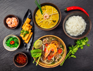 Asian food served on black stone, top view