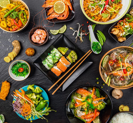 Asian food served on black stone, top view