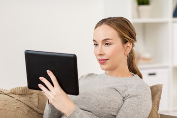 smiling woman with tablet pc at home