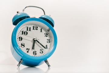 blue alarm clock on white background (in the morning and Wake up at work)
