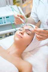 Obraz na płótnie Canvas на фото изображена молодая девушка на процедуре в косметологическом кабинете