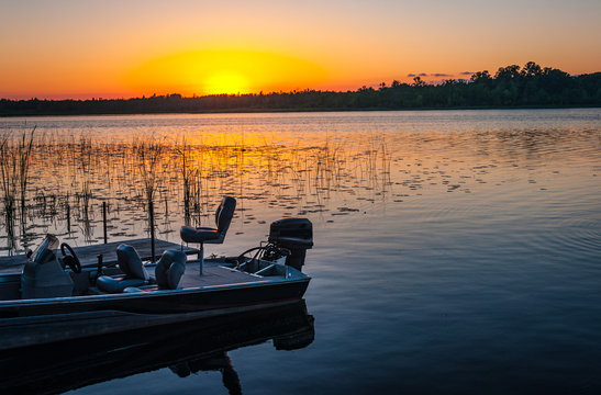 Fishing Boat On Tranquil Lake At Sunset In Minnesota