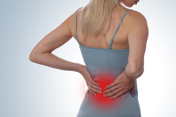 Back Pain. Woman rubbing muscles of her lower back. Sports exercising injury.