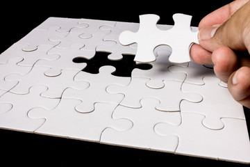 Hand completing a puzzle