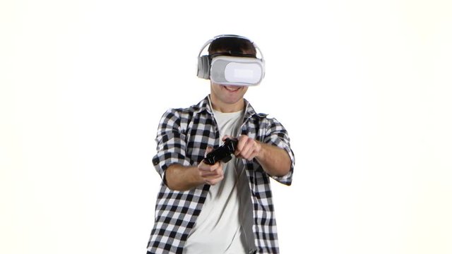 Man plays on gamepad with headphones and virtual reality glasses